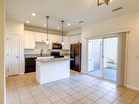 A kitchen with a white island and a refrigerator.